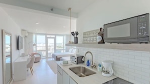A modern kitchen with a built-in microwave, a coffee maker, and a sink. - La Costal | Beachfront Studio Apt w/ Ocean View (Carolina)