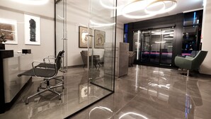 Un espace de bureau moderne doté de cloisons en verre, d’un espace d’accueil et de mobilier contemporain.