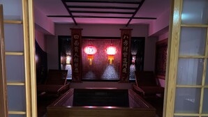 A traditional Japanese interior with wooden flooring, a red mat at the entrance, and red lanterns above a staircase. - Ofuro World Hotel Spa (Izmir)