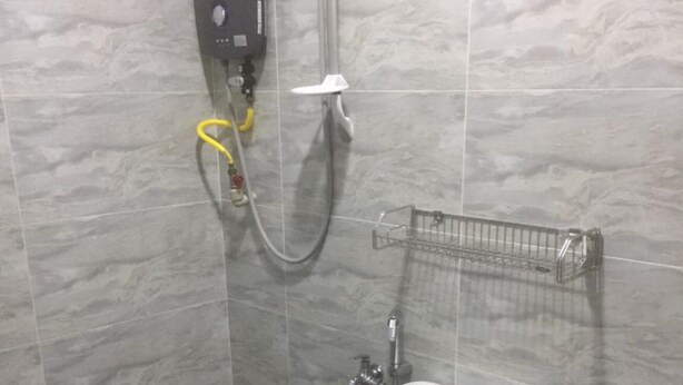 A bathroom with a toilet, a shower unit, and a sink. - OYO 90090 Roselyn Inn 2 (Pasir Gudang)