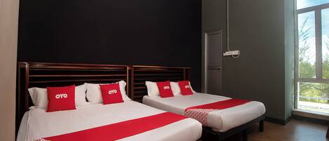 A hotel room with two beds, a window, and an air conditioning unit.