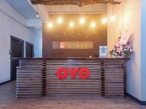 A reception desk with a wooden slat design, a prominent 'OYO' logo, and a QR code for digital check-in. - OYO 90094 Hi Inn 3 (Sibu)