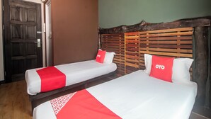 A hotel room with two beds, each with red and white bedding, and a wooden headboard.