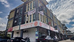 A multi-story building with signage for a medical clinic and laboratory.