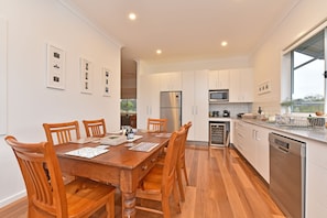 A modern kitchen with white cabinetry, a built-in microwave, and a stainless steel dishwasher.