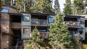 A multi-story building with balconies, surrounded by trees. - Mammoth Condo with Hot Tub (Mammoth Lakes)