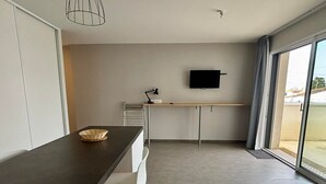 Una cocina moderna con comedor, televisor de pantalla plana y un amplio ventanal.