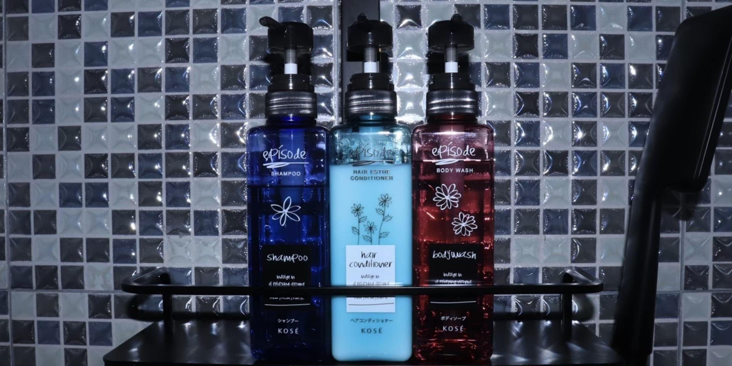 Three bottles of Episode hair care products on a shelf against a tiled wall.