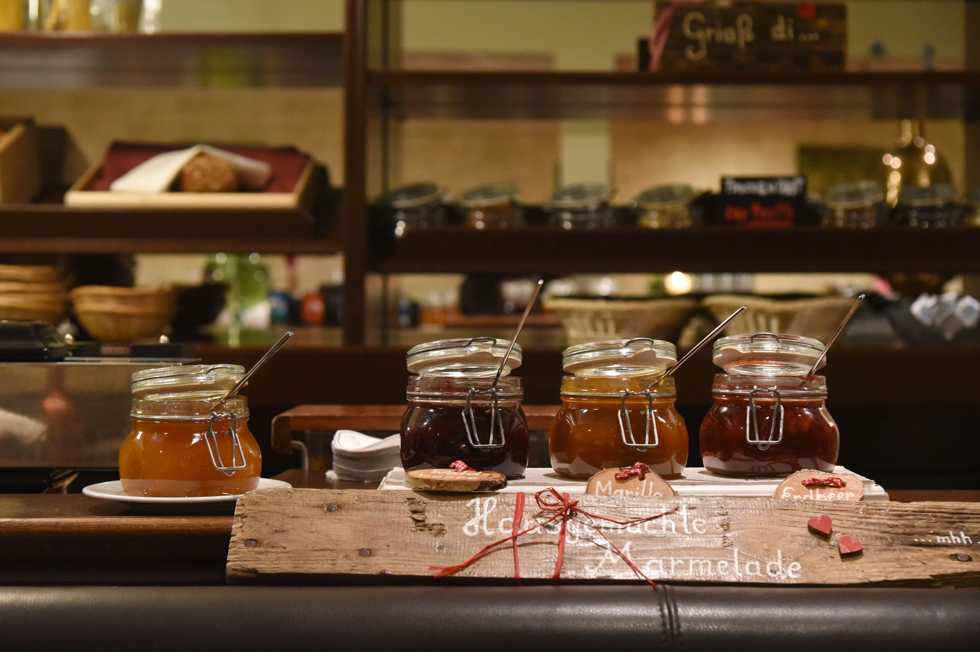 Una mesa de madera con frascos de miel y un letrero que dice 'Mermelada Artesanal'.
