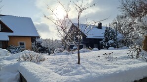 A residential area with snow-covered ground, a wooden fence, and houses with snow on their roofs. - High Franconia apartment  (Oberkotzau)