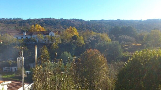 A house on a hill with a view of the surrounding landscape. - Guest House Casa dos Serpas (Nelas)
