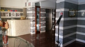 A reception area with a counter, a glass display case, and a wall-mounted photo collage. - Guest House Casa dos Serpas (Nelas)