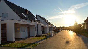 A row of modern houses with a paved driveway and a clear sky. - Lilja Vacation Home: Large Garden, Fireplace, Stone Grill, Dog-Friendly, Outdoor Pool, Beach Package (Trzęsacz)