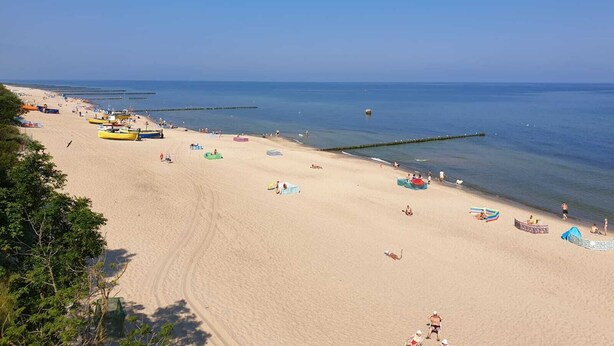 A wide sandy beach with clear blue water, several boats, and a few people. - Lilja Vacation Home: Large Garden, Fireplace, Stone Grill, Dog-Friendly, Outdoor Pool, Beach Package (Trzęsacz)