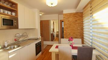 Una cocina moderna con microondas integrado, un fregadero y una zona de comedor con mesa y sillas.