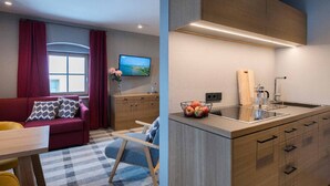 A modern living room with a sofa, a TV, and a window with curtains. - Hotel Gasthof Fuchs (Mauth)