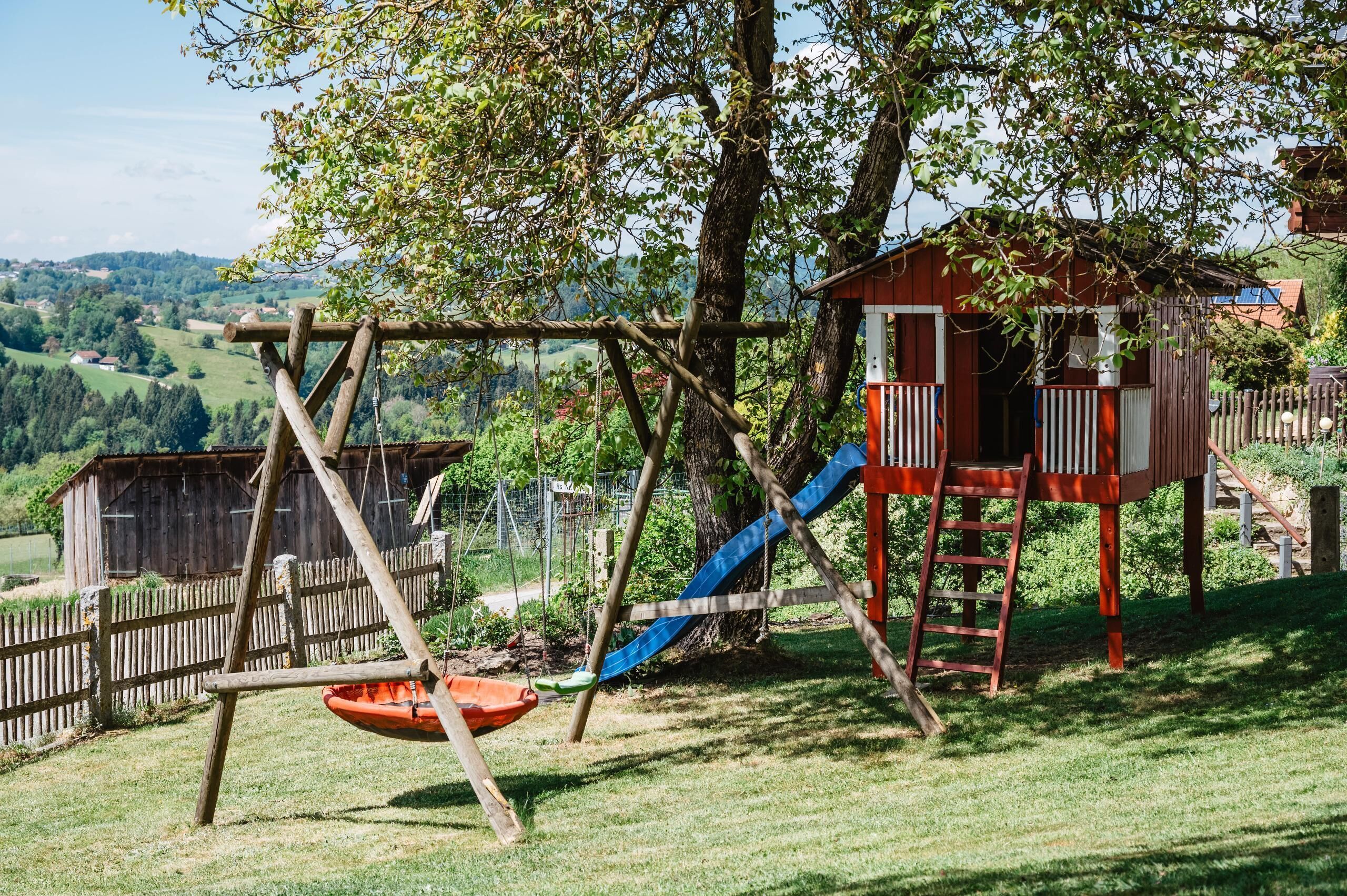 A playground with a swing set, slide, and climbing structure.