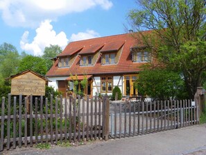 A traditional wooden house with a sign indicating it is a guesthouse. - Spatzenhof Weiltingen (Weiltingen)