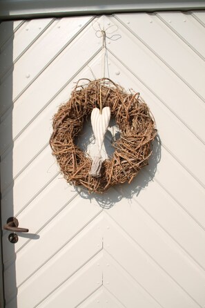 A white door with a circular wreath hanging on it. - Tauberlodge (Creglingen)