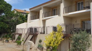 Un edificio a più piani con balconi, una scala e posti a sedere all'aperto.
