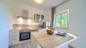 Een moderne keuken met een houten aanrechtblad, een inbouwoven en een fruitschaal.