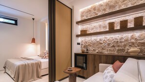 Una camera da letto moderna con un letto, un comodino e una TV integrata.