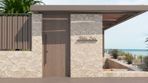 Eine moderne Villa mit Steinverkleidung, einer Holztür und Blick aufs Meer.