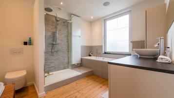 Bathtub, hair dryer, towels, toilet paper