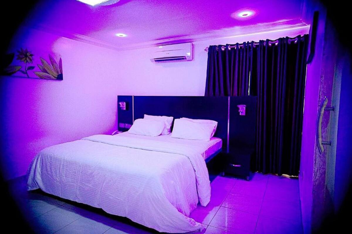 Una habitación con cama, cortinas y un aire acondicionado.