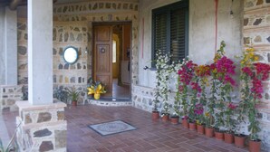 A stone building with a tiled entrance, a wooden door, and a window with shutters. - Villa Rosetta in the middle of nature, surrounded by palm and olive trees  (Pizzo)