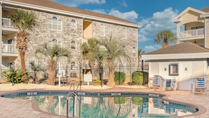 A pool area with a stone building, palm trees, and a 'No Swimming Allowed' sign. - A golf course view escape in the heart of Myrtle Beach! (Myrtle Beach)