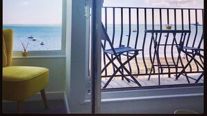A room with a view of the sea, a yellow chair, and a table with a glass. - Estuary Views Penthouse 🖤 Beachfront with Parking (Southend-on-Sea)