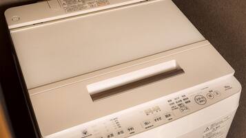 A white Toshiba washing machine with control panel and safety instructions.