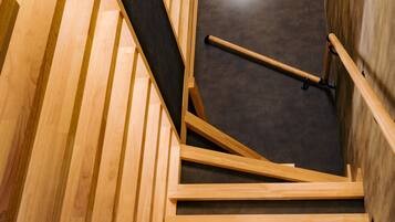 A wooden staircase with a dark floor.