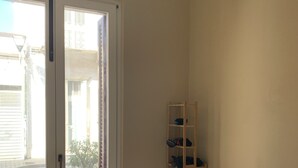 Een kamer met een bed, een houten plank en een potplant.
