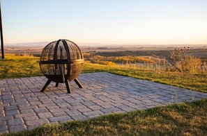 Una parrilla esférica al aire libre sobre una superficie pavimentada, con vistas a un paisaje distante.
