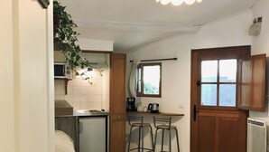 A compact living space with a kitchenette, a dining area, and a bed. - Mas de l'Acacia (Tavel)