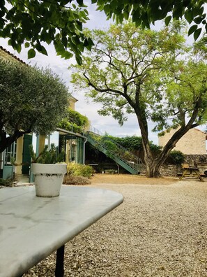 Un patio de grava con una mesa y una planta en maceta.