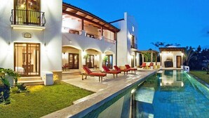 A modern house with a swimming pool, a covered patio, and a well-maintained lawn. - Casa Orchidea (Tamarindo)