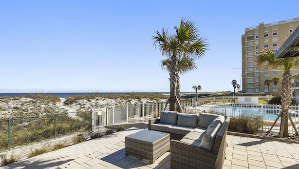 Une terrasse sur le toit, aménagée avec du mobilier d’extérieur, une piscine et une vue sur la plage et l’océan.