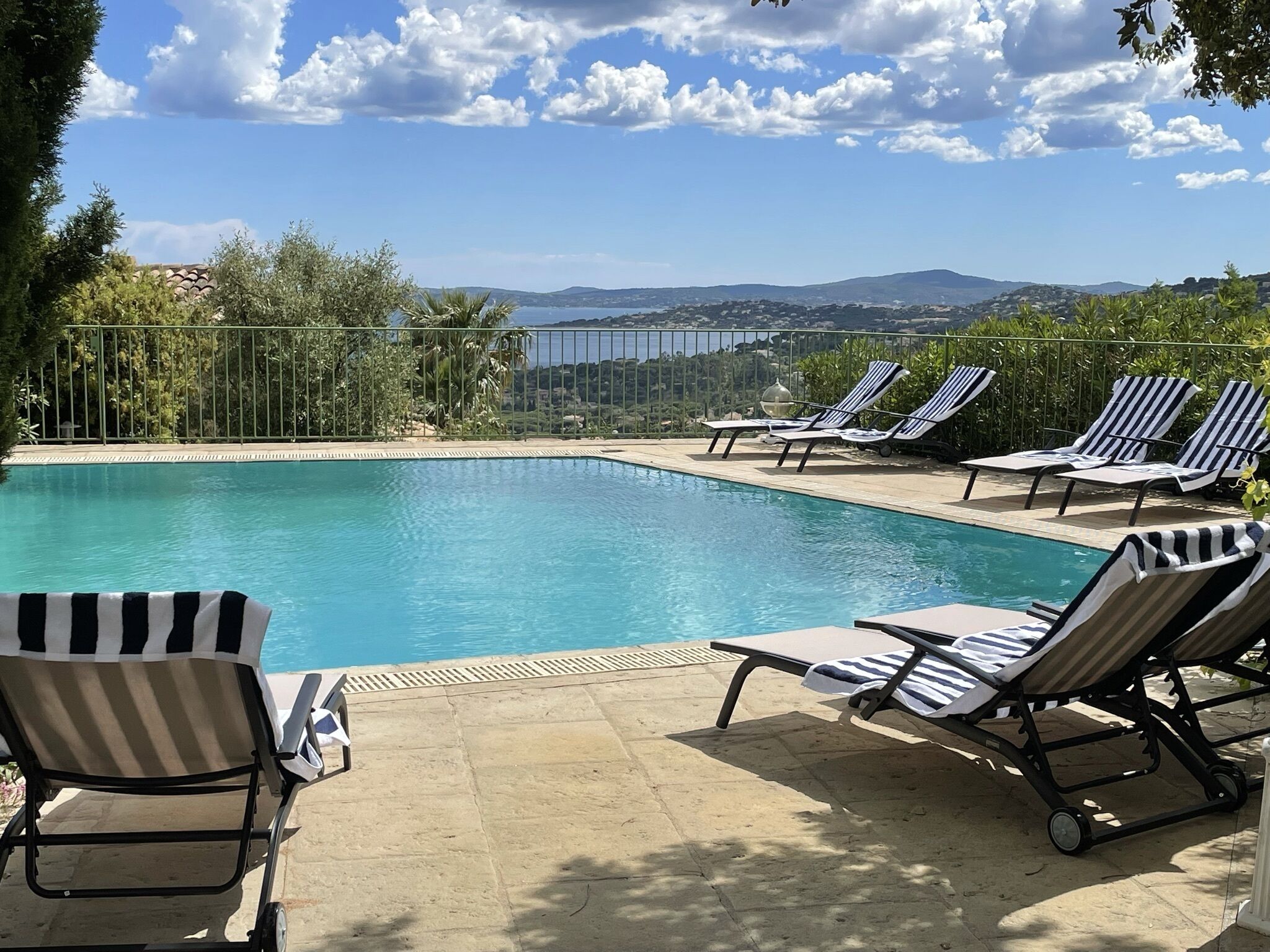 Ein Swimmingpool mit Liegestühlen und Blick auf die Landschaft.
