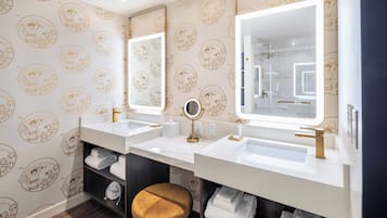 Un baño con dos lavamanos, un espejo y un perchero para toallas.