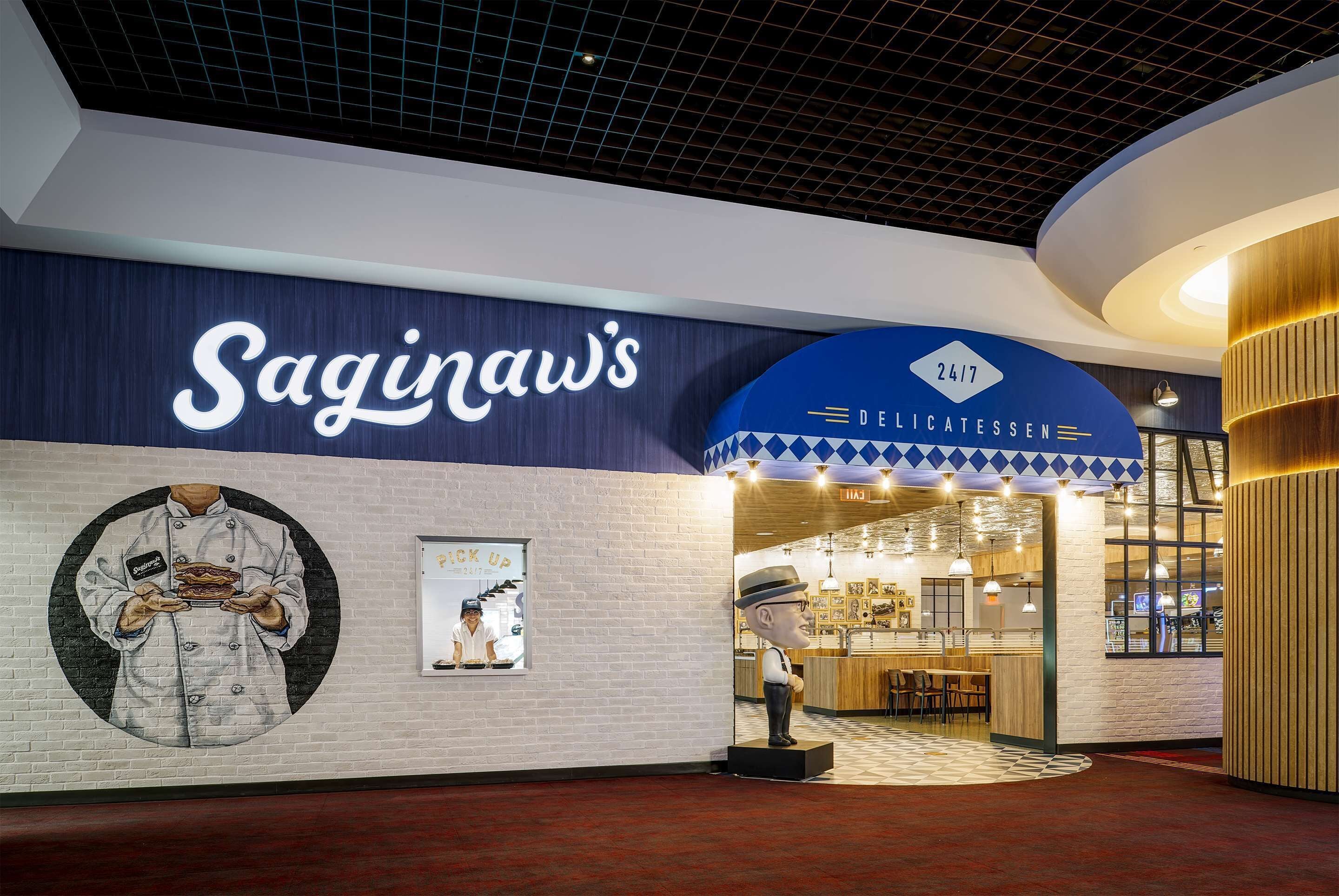 A restaurant interior with a modern design, featuring a prominent sign for 'Saginaw's' and a '24/7' service indication.