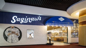 A restaurant interior with a modern design, featuring a prominent sign for 'Saginaw's' and a '24/7' service indication.