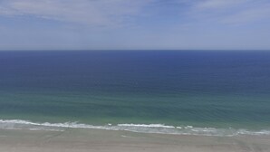 Une plage avec un ciel dégagé et une mer calme.