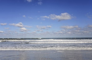 A beach with waves and a clear sky.