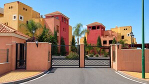 A gated entrance to a residential area with a clear sky. - Rincón del Golf III - Planta Baja - Beach & Golf (Isla Canela)