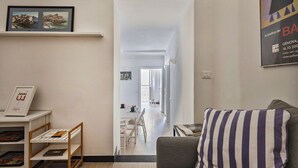 Un soggiorno moderno con un cuscino a righe, una libreria e un quadro incorniciato al muro.