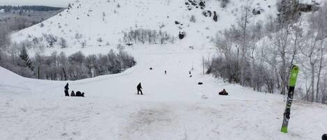 A snowy ski slope with skiers and snowboarders.