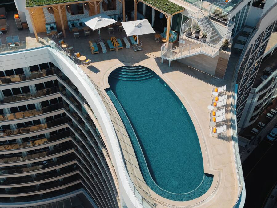 Ein modernes Hotel mit Dachpool, Außenbereichen zum Sitzen und einer gläsernen Lounge.